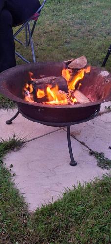 a grill with fire in it on a sidewalk at Hendre Glamping Retreat, The Rabbit Warren in Clydey