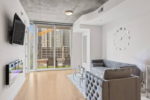 a living room with a couch and a large window at Atlanta Midtown High-Rise Condo With King Bed Free Parking and Balcony With View in Atlanta