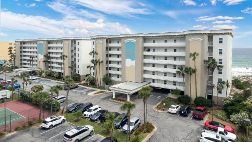 an apartment building with cars parked in a parking lot at Gulf Dunes 106 Gulf Front condo in Fort Walton Beach