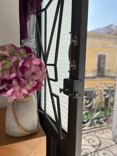 a door with a flower in a vase next to a window at Hotel Alhaja Puebla Centro Histórico in Puebla
