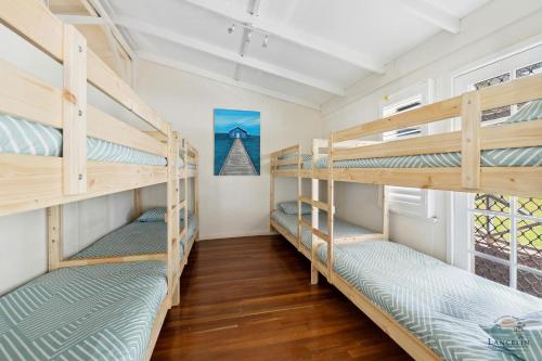 a room with three bunk beds in a house at Barefoot on O'Neil in Lancelin