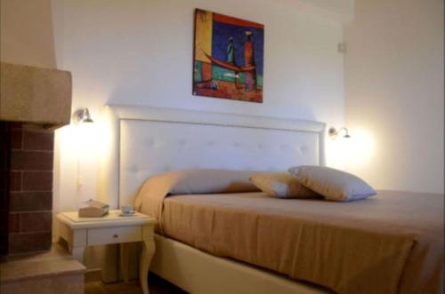 a bedroom with a bed and a painting on the wall at Agriturismo Masseria San Leonardo in Savelletri di Fasano