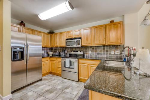 a kitchen with wooden cabinets and stainless steel appliances at River View Condo Sleeps 6 Shared Hot Tub & Pool in Pigeon Forge