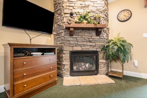 a living room with a stone fireplace with a tv at Downtown Summit Manor Sleeps 8 Mtn Views Pool in Gatlinburg