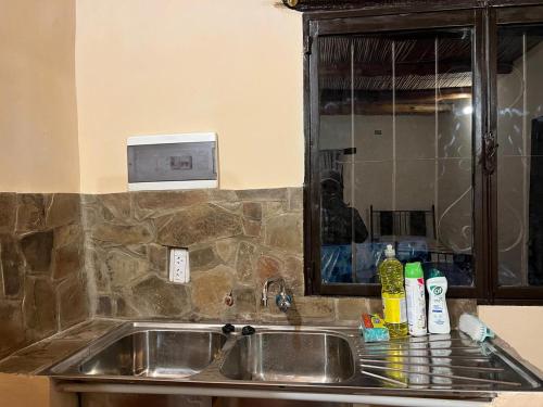 a kitchen counter with a sink and a mirror at Cabañas Puesta del Sol in Purmamarca