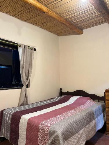 a bedroom with a bed in a room with a window at Cabañas Puesta del Sol in Purmamarca