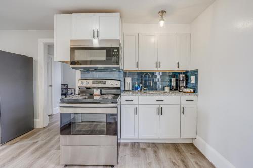 a kitchen with white cabinets and a stove top oven at Weymouth Apartment Close to Beaches and Boston! in Weymouth