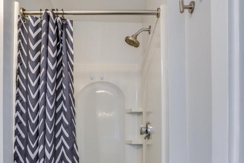 a shower door with a blue and white striped shower curtain at Weymouth Apartment Close to Beaches and Boston! in Weymouth