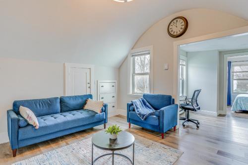 a living room with two blue couches and a clock at Weymouth Apartment Close to Beaches and Boston! in Weymouth