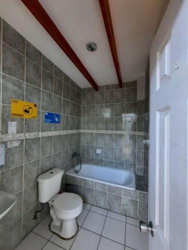 a bathroom with a toilet and a bath tub at Casa centro de Arica in Arica