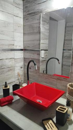 a red sink with two faucets on a bathroom counter at El encanto in Santa María