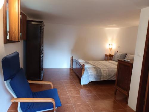 a bedroom with a bed and a blue chair at Carneiro Country Houses Casa das Batatas in Amarante