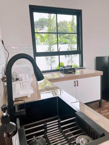 a kitchen counter with a sink and a window at Casa de Gaudete 3 Bedroom King Size Villa Lembang in Genteng