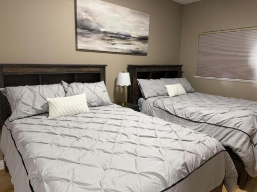 a bedroom with two beds and a painting on the wall at Lakeshore Villa Estates in Osoyoos