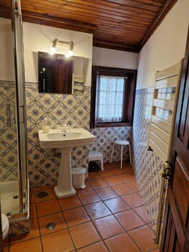 a bathroom with a sink and a mirror at Carneiro Country Houses Casa do Avô in Carneiro