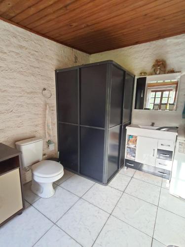 a bathroom with a toilet and a sink and a cabinet at Sítio do Berger 1 in São Gabriel