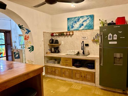 a kitchen with a green refrigerator and a counter at Casa Samay in Cozumel
