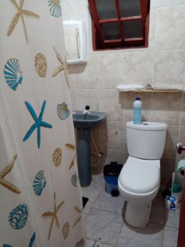 a bathroom with a toilet and a shower curtain at Isabella in Xuí
