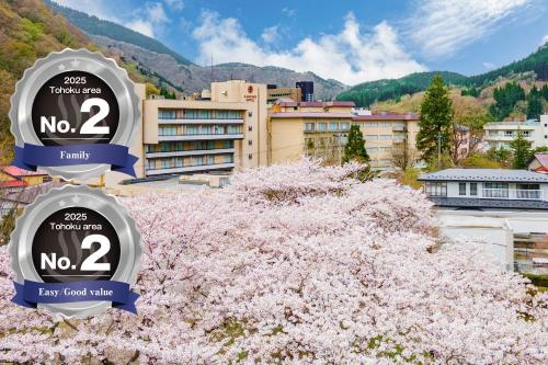 a tree with pink flowers in front of a building at KAMENOI HOTEL Akita Yuze in Kazuno