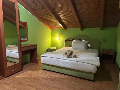 a green bedroom with a bed with shoes on it at Restoran Gurman in Kraljevo