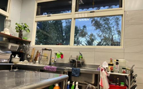 a kitchen with a sink and two windows at 十畝田山莊 in Chishang