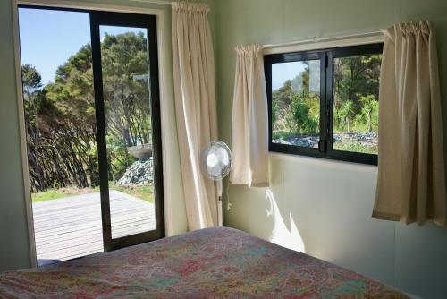 a bedroom with a bed and a large window at Estuary Escape in Kaingaroa