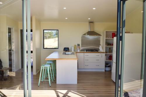 a kitchen with white cabinets and a counter top at Estuary Escape in Kaingaroa