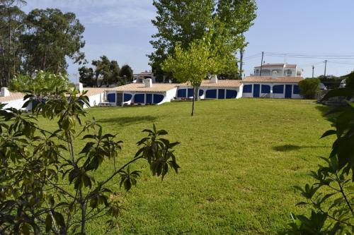 une maison dans un champ avec un arbre au premier plan dans l'établissement Remodelada Villa nos Jardins da Balaia, à Albufeira