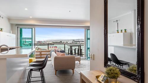 a kitchen and living room with a view of the water at QV Stays Elegant Modern Apartment with Water Views in Auckland