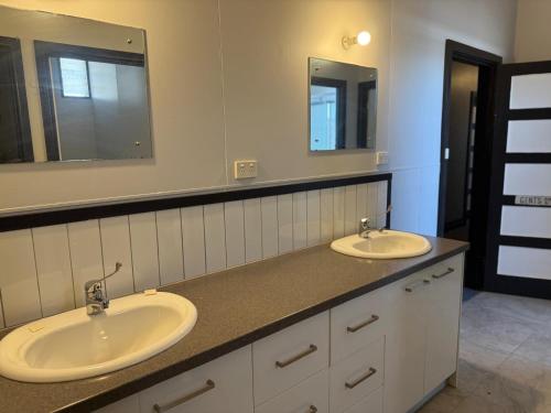 a bathroom with two sinks and two mirrors at Golden Age Hotel in Beaufort