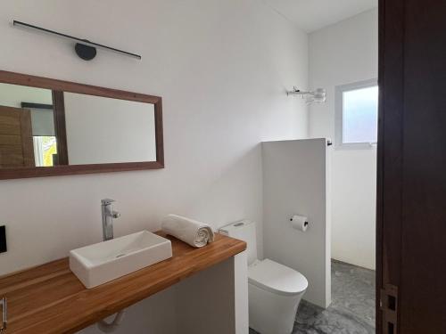 a bathroom with a sink and a toilet and a mirror at Casa Olivia - Eureka in Atins