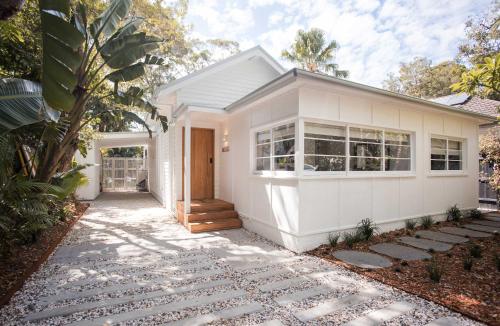 a white house with a pathway leading to it at Moso House Pearl Beach in Pearl Beach