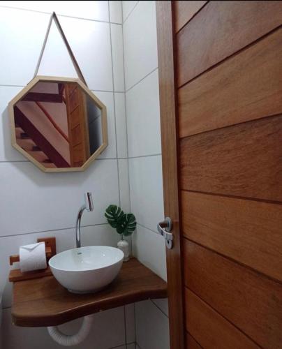 a bathroom with a sink and a wooden door at Villa do Sol Sagi in Baía Formosa