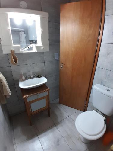 a bathroom with a toilet and a sink and a mirror at La Pradera in Tres Picos