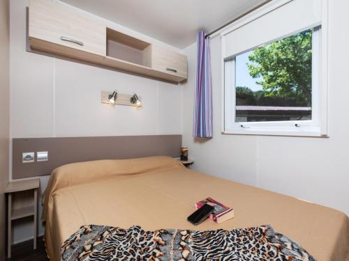 a small bedroom with a bed and a window at Cozy mobile home in Cesenatico in Cesenatico
