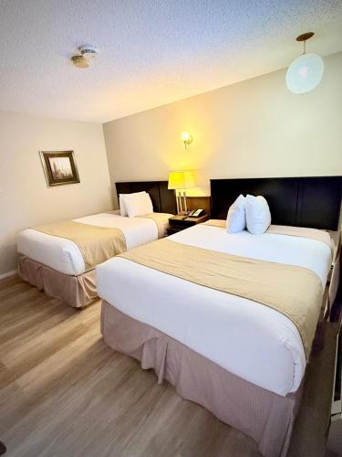 a hotel room with two beds and a lamp at Melville Country Inn in Melville