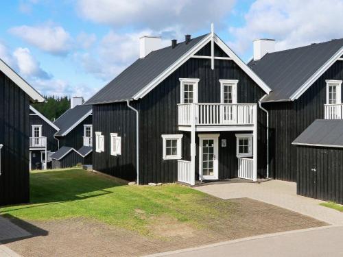 a black barn with white trim and a yard at 8 person holiday home in Gjern-By Traum in Gjern
