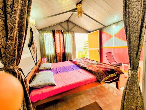 a bedroom with a bed in a tent at Himvadi Resorts Kausani in Kausani