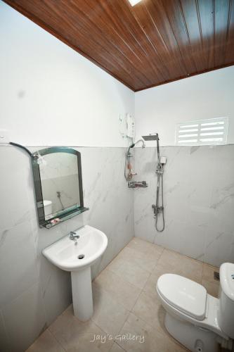 a bathroom with a sink and a toilet and a mirror at Eden Udawalawe in Udawalawe
