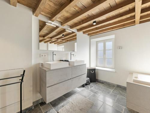 a white bathroom with two sinks and a window at Mansion in Aywaille with sauna in Aywaille