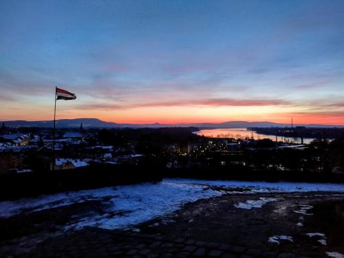 a flag on a pole with a sunset in the background at City-Top Panorama House & Apartments in Esztergom