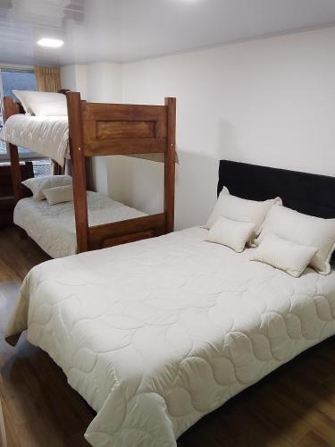 a bedroom with two bunk beds with white pillows at Hospedaje Santa Barbara in Tabio