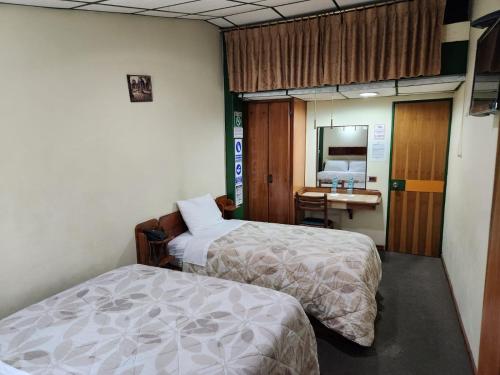 a hospital room with two beds and a desk at Hotel Piquellan in Quito