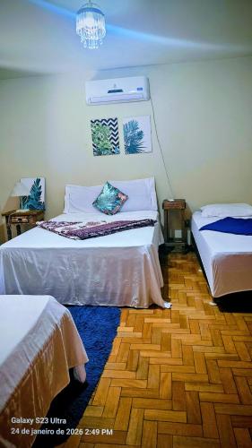 ein Schlafzimmer mit zwei Betten und einem Kronleuchter in der Unterkunft Mimi Nova in Osório