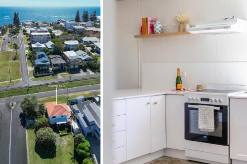 a kitchen with white cabinets and a view of a city at Coastal Echo - Oceanstays - Pet Friendly in Yamba