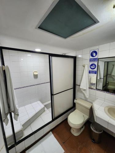 a bathroom with a toilet and a sink at Hotel Piquellan in Quito