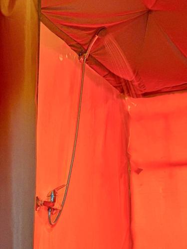 a red tent with a hose attached to it at Merzouga heritage camp in Merzouga