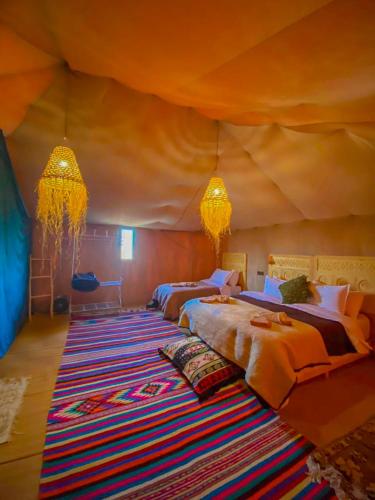 a bedroom with two beds in a tent at Merzouga heritage camp in Merzouga