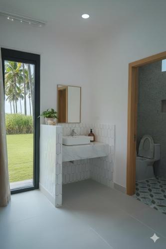 a bathroom with a sink and a mirror at Villa Santoni Mũi Né in Mui Ne