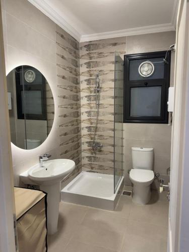 a bathroom with a sink and a toilet and a shower at Celia new capital 3 bedrooms in Cairo
